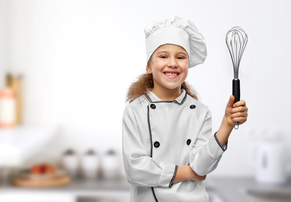 cooking, culinary and profession concept - happy smiling little girl in chef&rsquo;s toque and jacket with whisk over kitchen background. smiling little girl in chef&rsquo;s toque with whisk