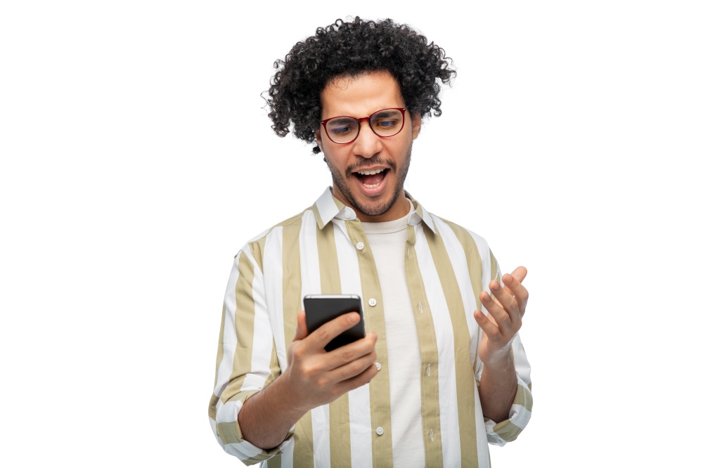technology, communication and people concept - displeased man in glasses with smartphone over white background. displeased young man with smartphone