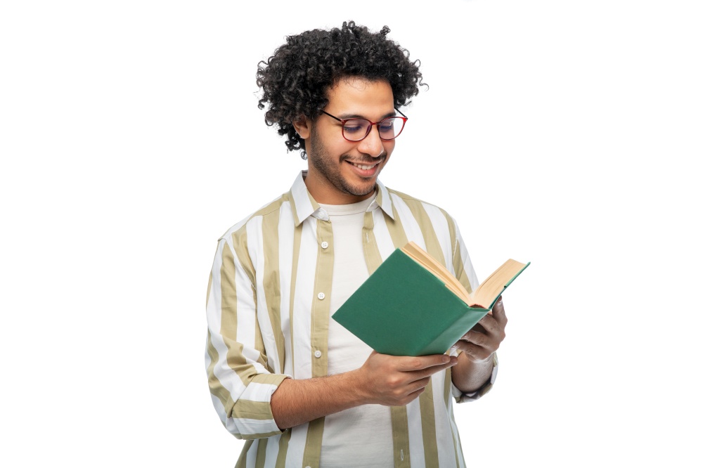 knowledge, education and people concept - happy smiling young man in glasses reading book over white background. happy young man in glasses reading book