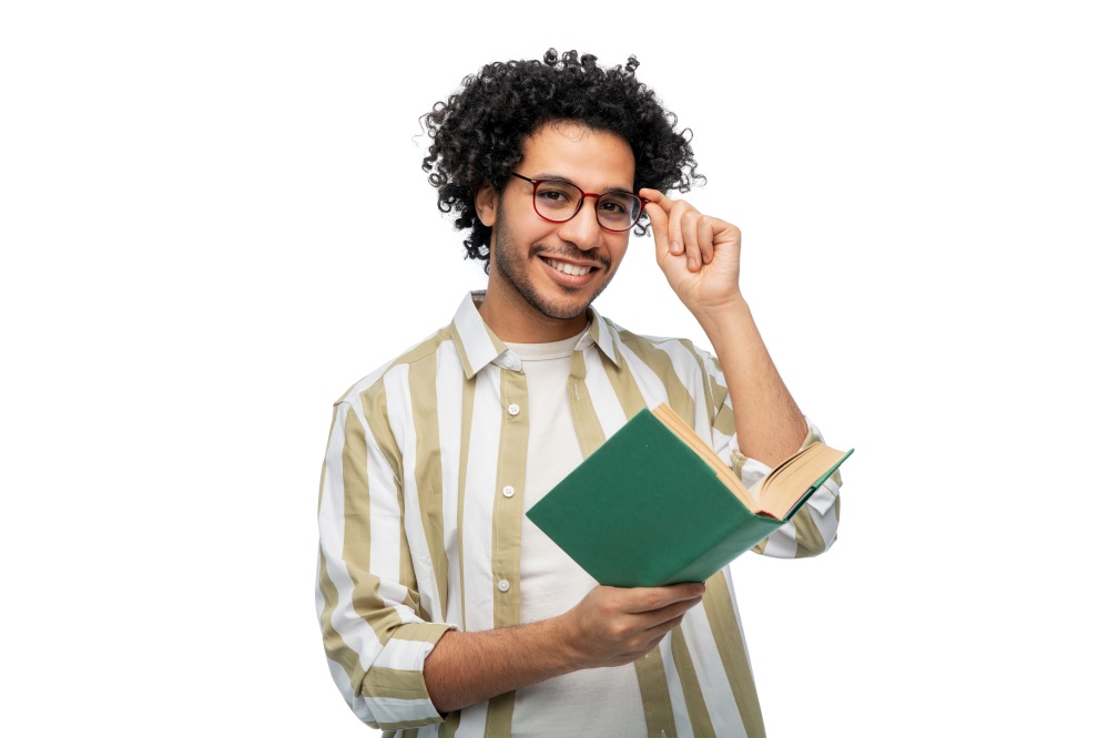 education, vision and people concept - happy smiling young man in glasses reading book over white background. happy young man in glasses reading book