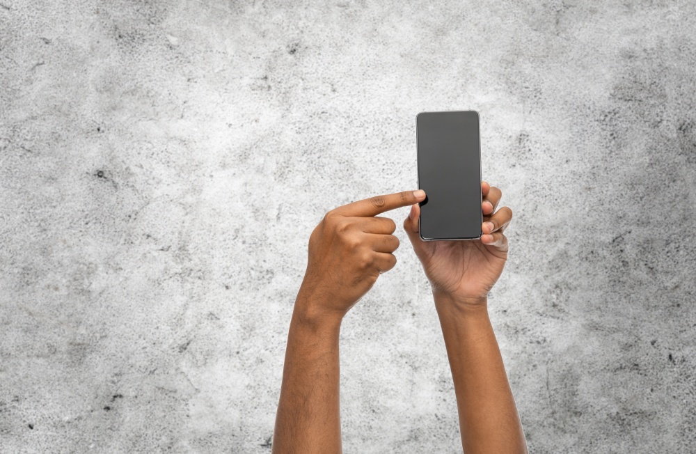 technology and people concept - close up of female hand sholding smartphone over grey stone wall background. close up of hands holding smartphone