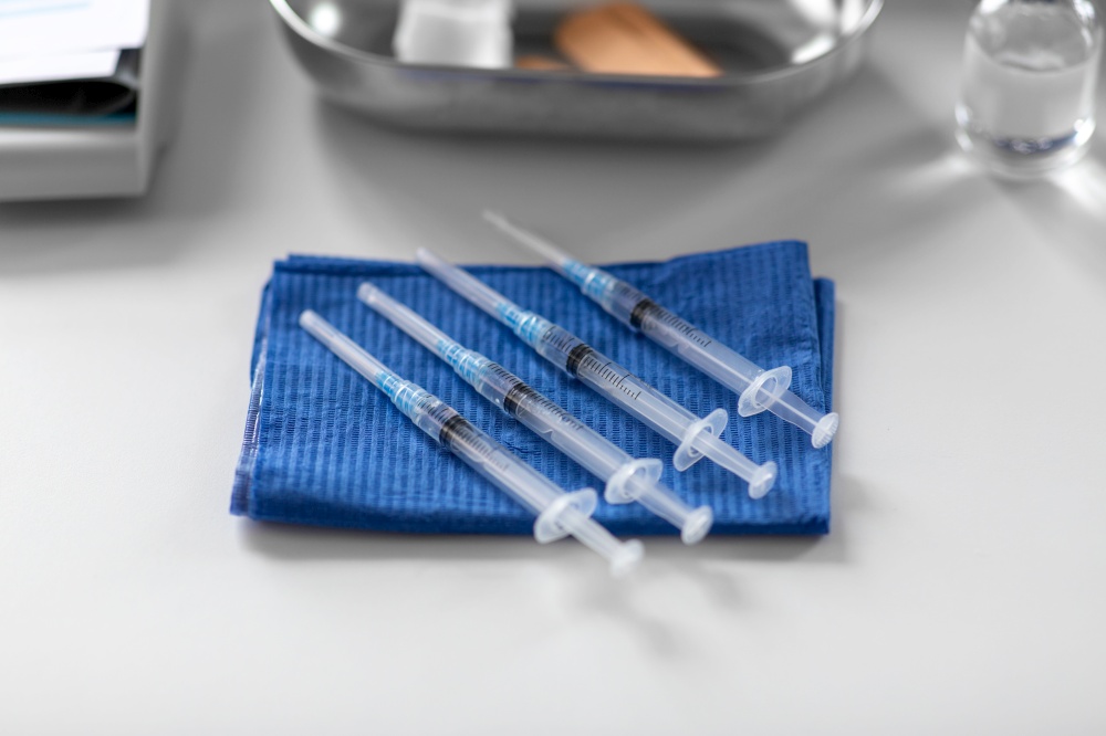 medicine, vaccination and healthcare concept - disposable syringes on blue wipe on table at hospital. disposable syringes on blue wipe on table