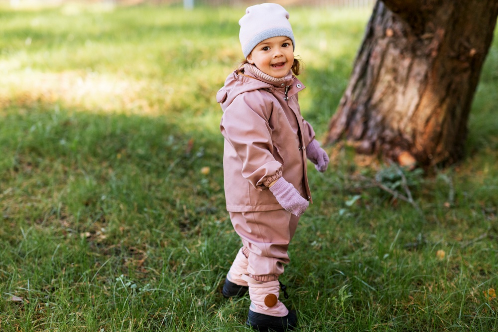 childhood, leisure and season concept - happy little baby girl walking in autumn park. happy little baby girl walking in autumn park