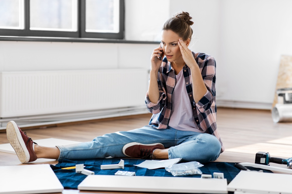 repair, improvement and furniture concept - stressed woman assembling new locker and calling on smartphone at home. woman assembling furniture and calling on phone