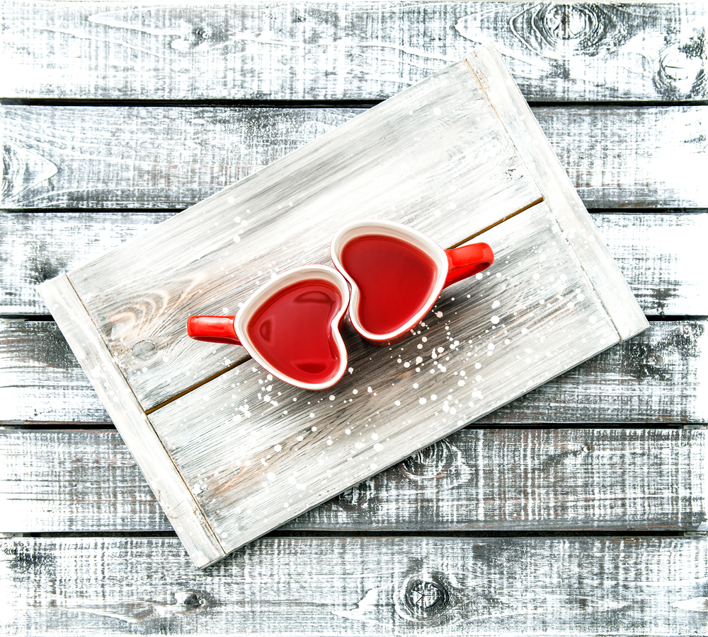 Heart shaped cups with red tea drink on rustic wooden background. Valentines day concept
