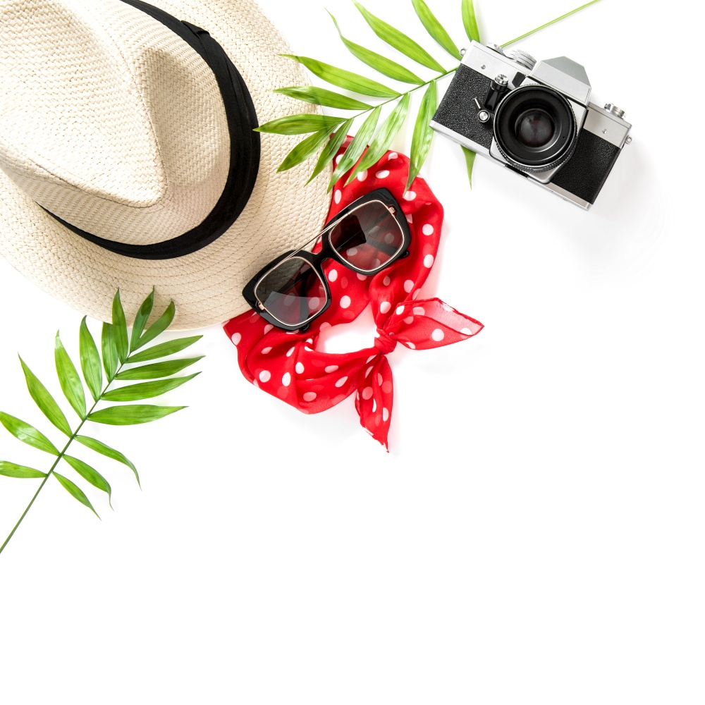 Floral summer flat lay. Palm leaves, sunglasses, photo camera, straw hat
