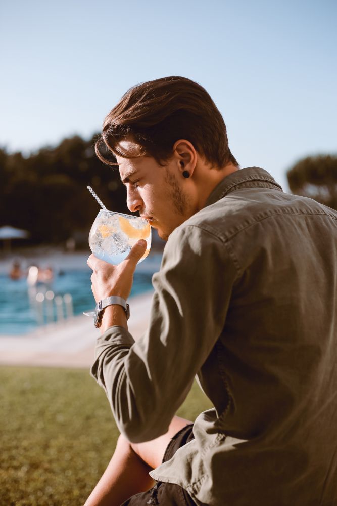 Man drinking cocktail near the pool - Spring and Summer