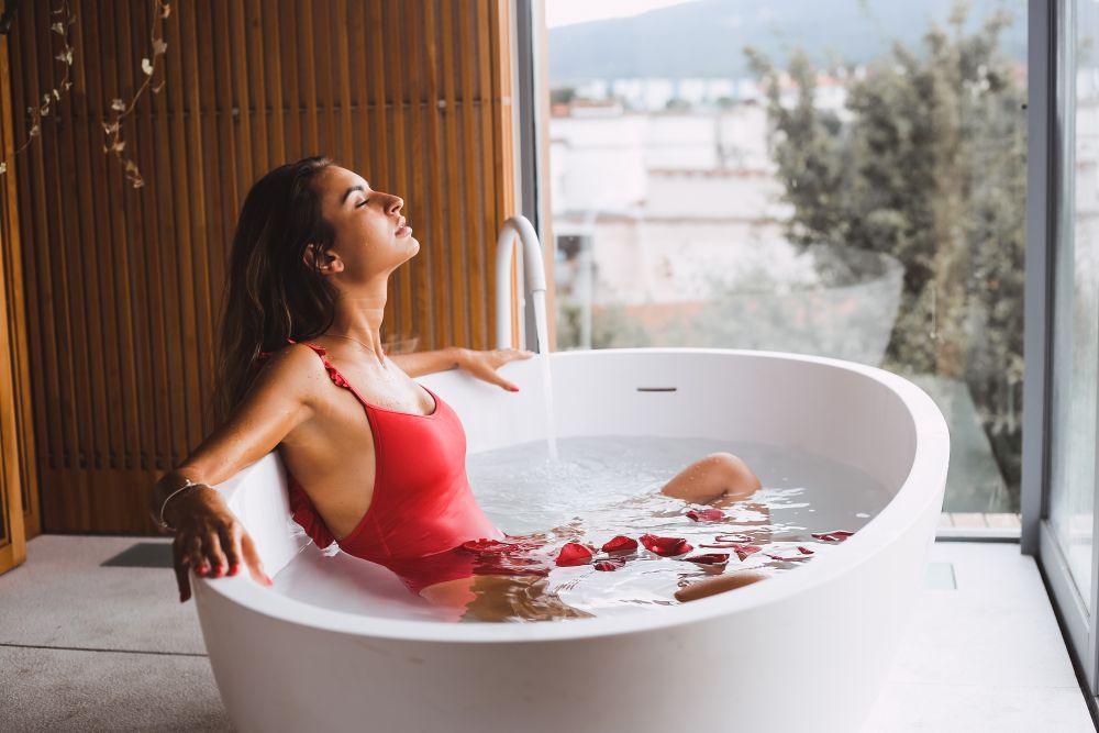 Woman bathing and relaxing in a modern bath tub