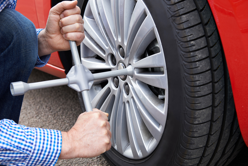 Close Up Of Man With Tyre Iron Changing Car Wheel