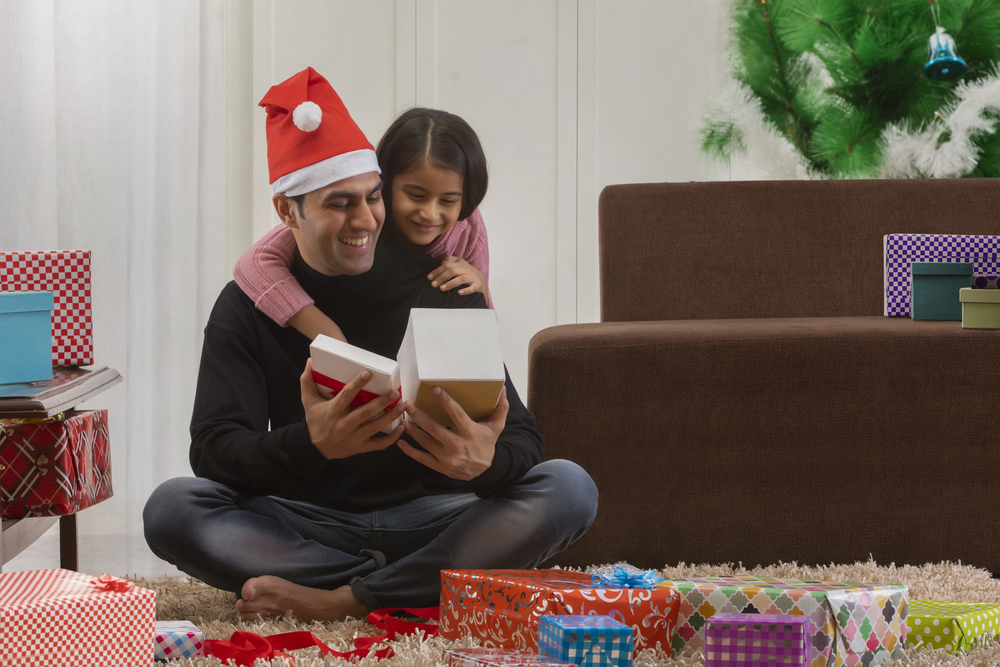 Father opening a present with daughter at Christmas