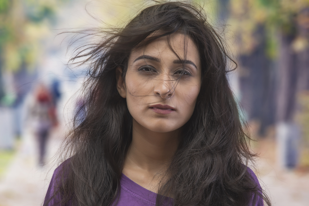 Portrait of young woman with dishevelled hair on the street