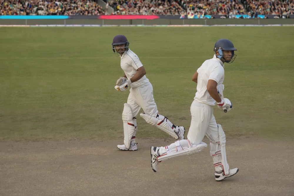 Cricketers, batsmen cross eaching other while taking a runduring a match