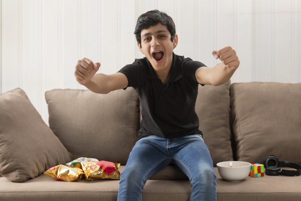 AN EXCITED TEENAGER EXPRESSING HAPPINESS WHILE EATING SNACKS