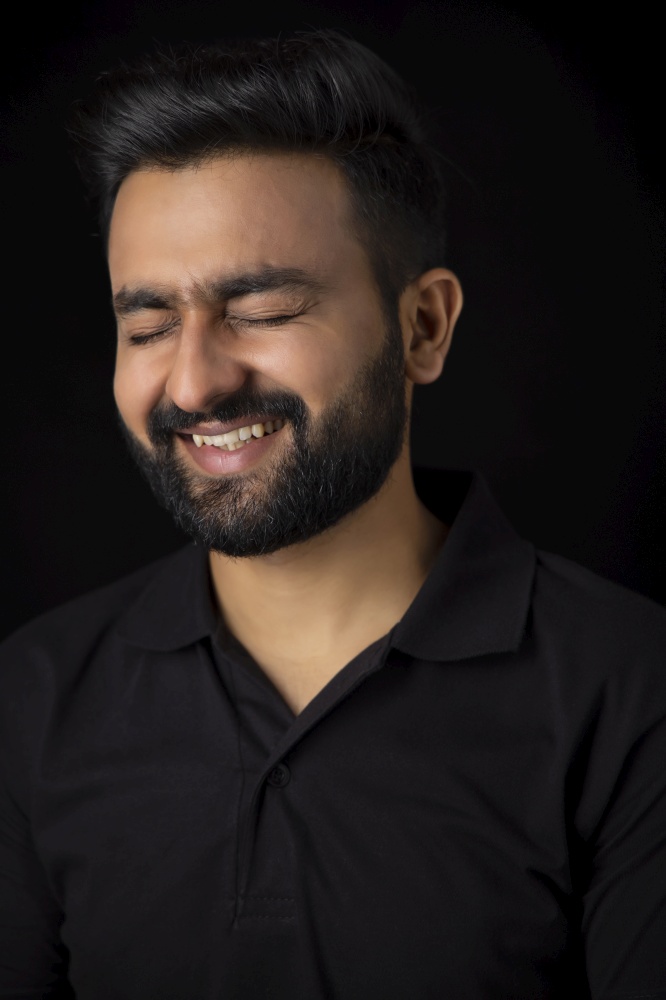 PORTRAIT OF A SMART BEARDED MAN LAUGHING