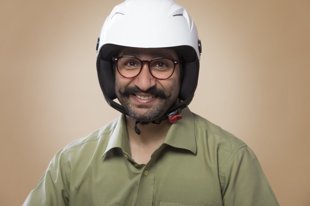 Close up of a smiling man wearing riding helmet.