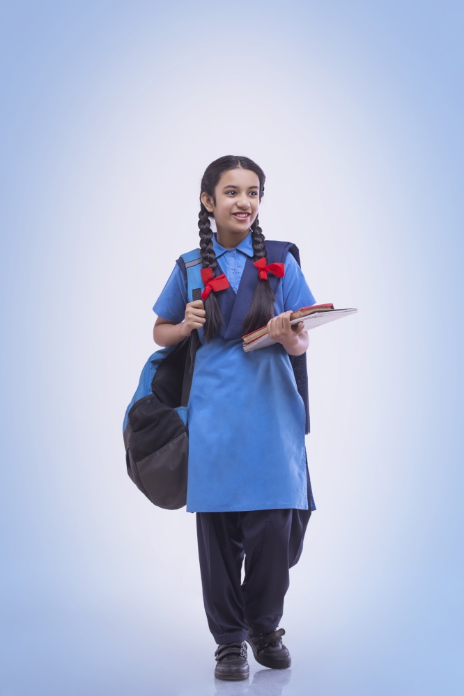 Portrait of school girl holding book and bag
