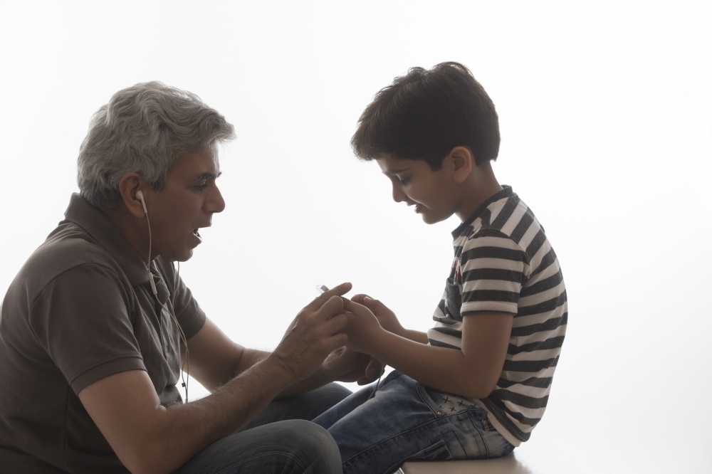 Grandfather and grandson listening to music with earphones