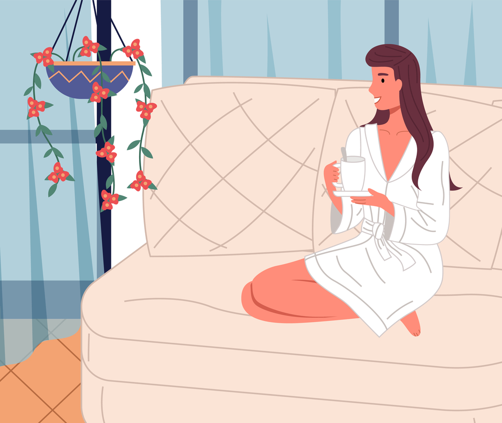 Happy smiling woman wearing bathrobe relaxing at sofa with a cup of drink at home. Cheerful brunette looking at curtains and hanging houseplant. Relaxation with tea or coffee after work at home. Happy smiling woman wearing bathrobe relaxing at sofa with a cup of drink at home, cheerful brunette