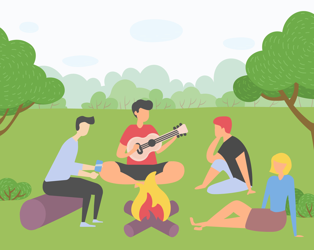 Young company of friends on picnic outside the city. Campfire gatherings, singing songs on the guitar, shoot on smartphone. Trip out of town or city park. Rest and vacation. Harvest festival in Europe. Friends on picnic outside a city, guy plays guitar, girl sits on grass, man scroll smartphone