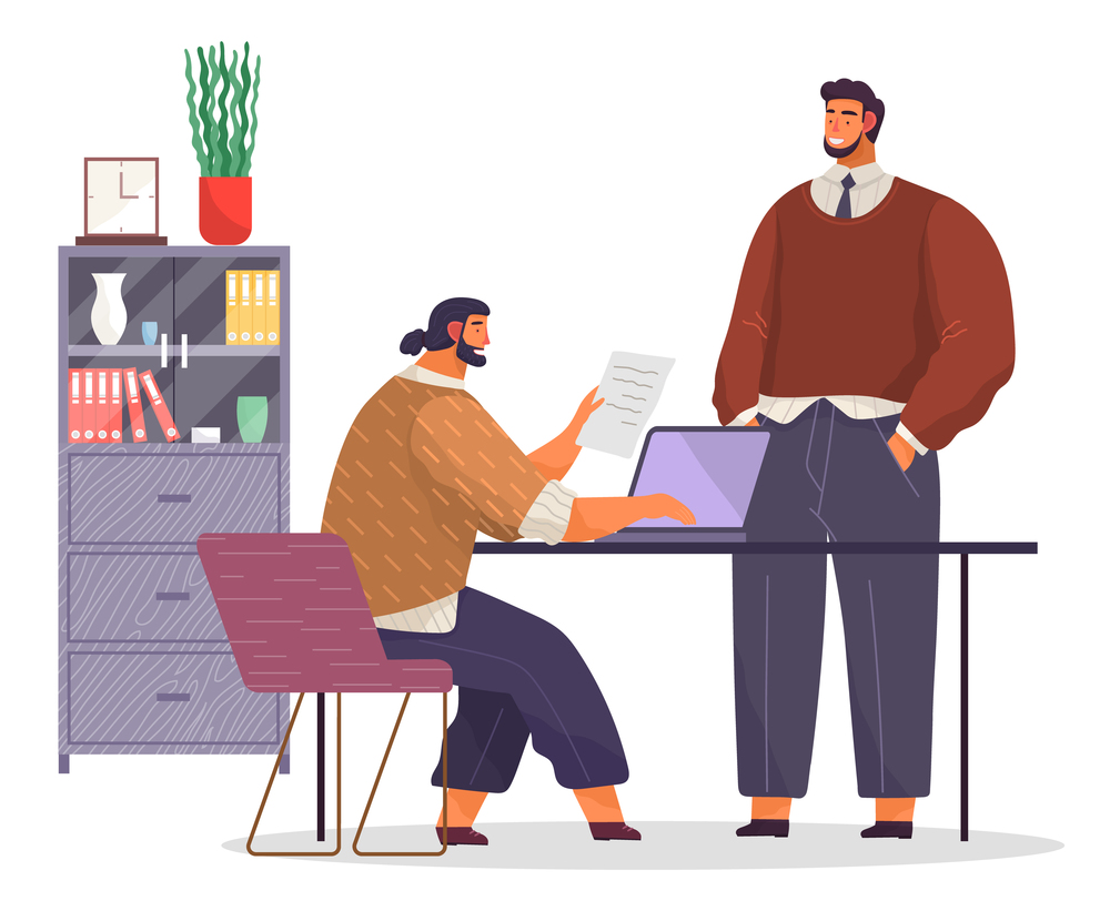 Office working space. Bearded man with fashionable haircut sits on chair at table, works at laptop, typing document. Black-haired man stands and smiles. Bookcase with books, folders, potted plant. Office workers in office. Bearded man smiles, employee sits at table, holds document, typing