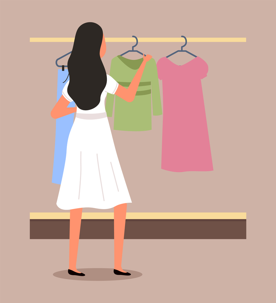 Girl chooses clothes on the hanger on shopping. Female buyer is selecting clothes in a store. Young beautiful fashion girl is standing near the stand with clothes. Shopper during the sale in a shop. Girl chooses clothes on the hanger on shopping. Female buyer is selecting clothes in a store