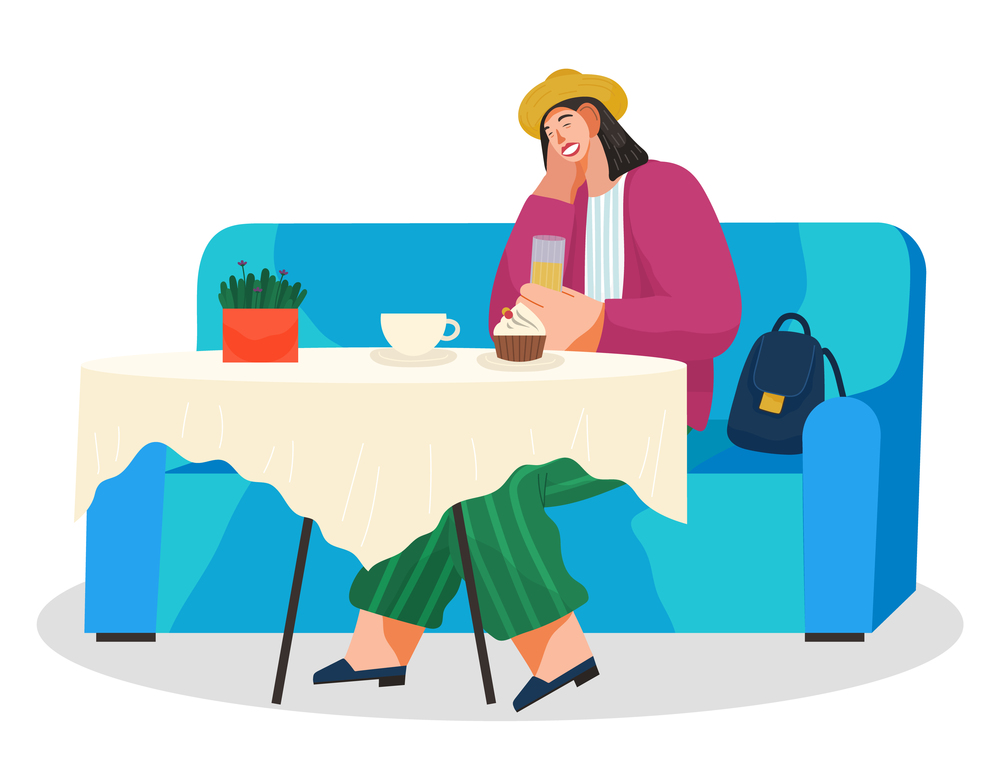 Young woman sitting on blue couch at a table eating cupcake drinking coffee. Female character having lunch in a restaurant with sweet dessert and juice. Stylish girl in a cafe talking on a cell phone. Young woman sitting on blue couch at a table eating cupcake drinking coffee in a restaurant