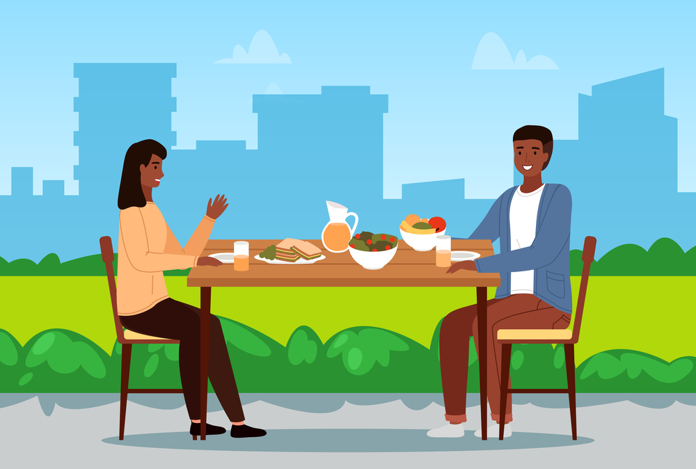 Table with fruit, salad and sandwiches. Couple eating natural food. People are having dinner outdoors. Characters on a date in the park. Afro American people communicate and spend time together. Couple is eating natural fresh food. Afro american people are having dinner together outdoors