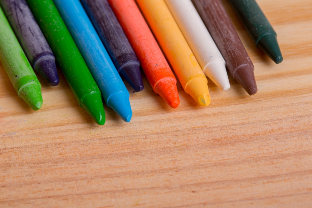 Wax crayons on a wooden background