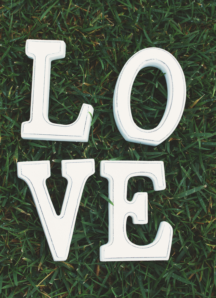 White letters Love on green grass background, instagram  retro filter