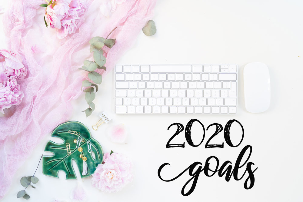 Top view 2019 goals with modern keyboard with female accessories and fresh peony flowers. Top view home office workspace