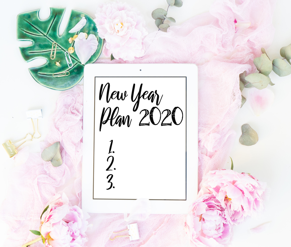 Creative New 2020 year planner composition mock up, pink blanket, flowers on white background, copy space on screen. Flat lay, top view stylish art concept.. Creative wedding composition
