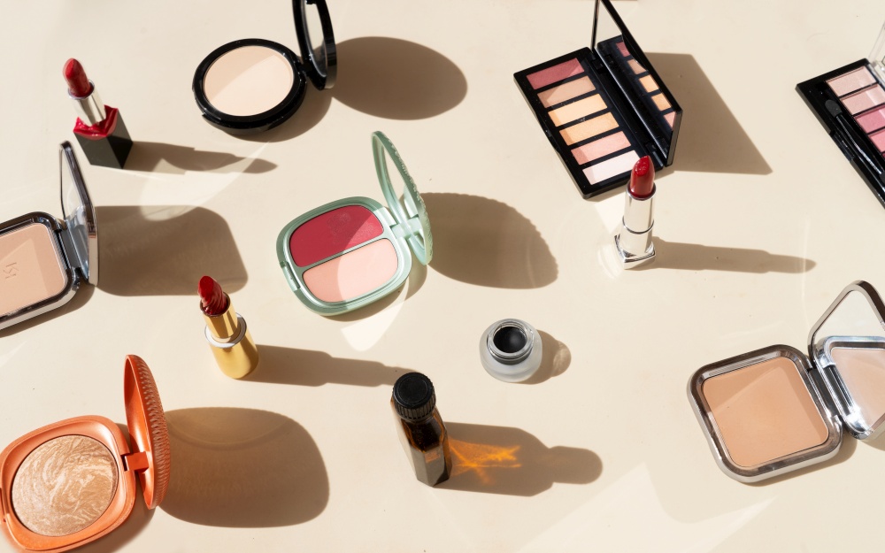 Minimal cosmetic scene with make up brushes, blush, powder, eye shadows, lipstick. make up brushes