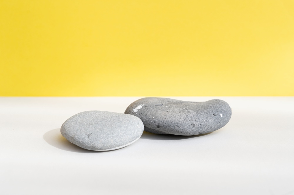 Minimal modern product display on textured gray and yellow background with shadows. Minimal product display