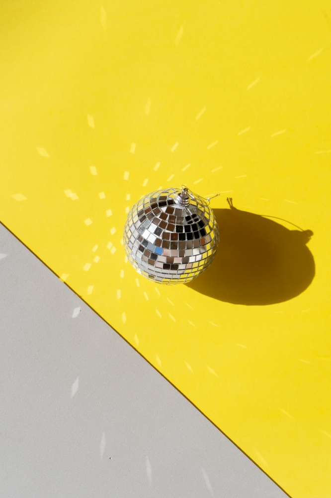 One disco balls on ulitimate gray and illuminating yellow background. Disco balls on blue background