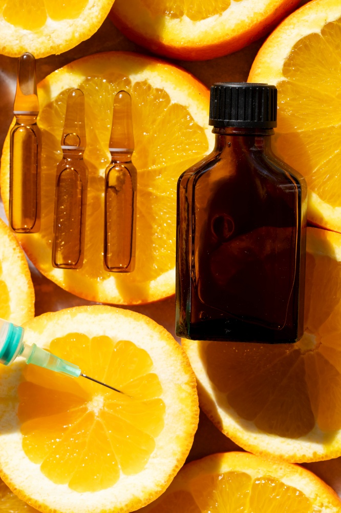 Citrus fruit vitamin c serum oil beauty care in ampullas and bottle close up, anti aging natural cosmetic.. Citrus fruit vitamin c serum oil beauty care