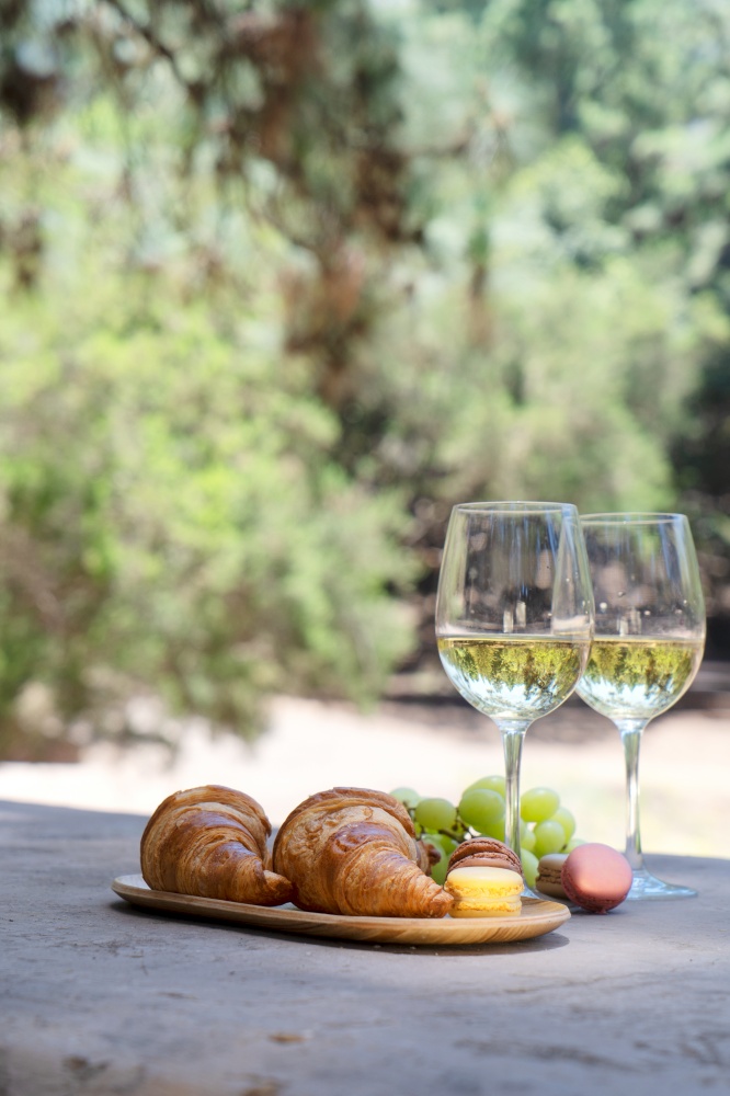 picnic with white wine and croissants in the forest. picnic with wine