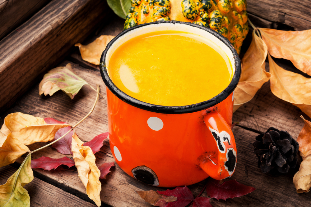 Pumpkin smoothie in a metal mug on vintage table.Autumn drink.. Beverage with pumpkins