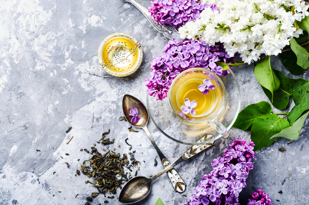 Tea and bouquet of beautiful spring flowers.Relaxation concept. Cup of tea and lilac flowers