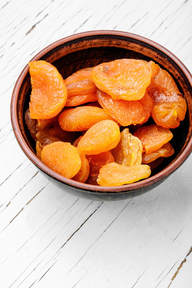 Delicious dried apricots in a bowl on white background. Dried apricots in the bowl