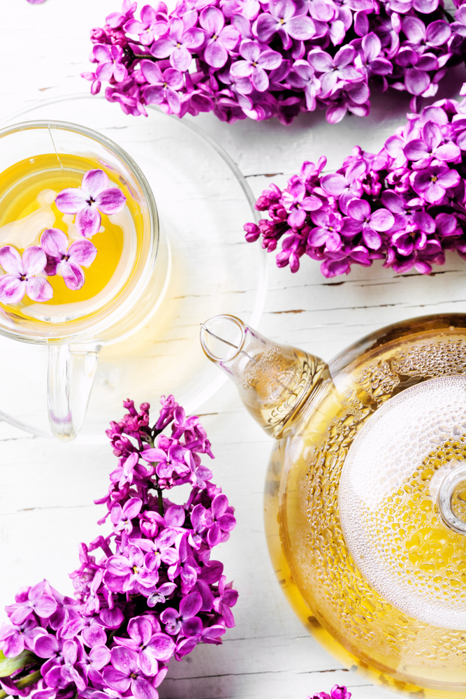 Tea and bouquet of beautiful spring flowers.Herbal tea. Cup of tea and lilac flowers