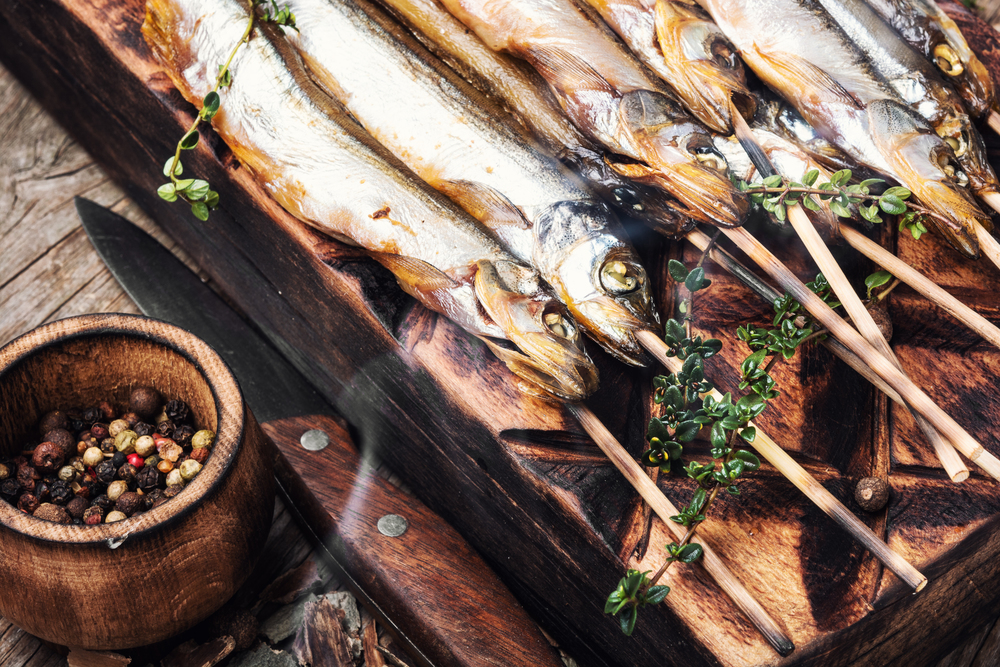 Smoked fish with spices.Cold smoked fish.Smoked capelin.Food industry. Smoked fish in a smoker