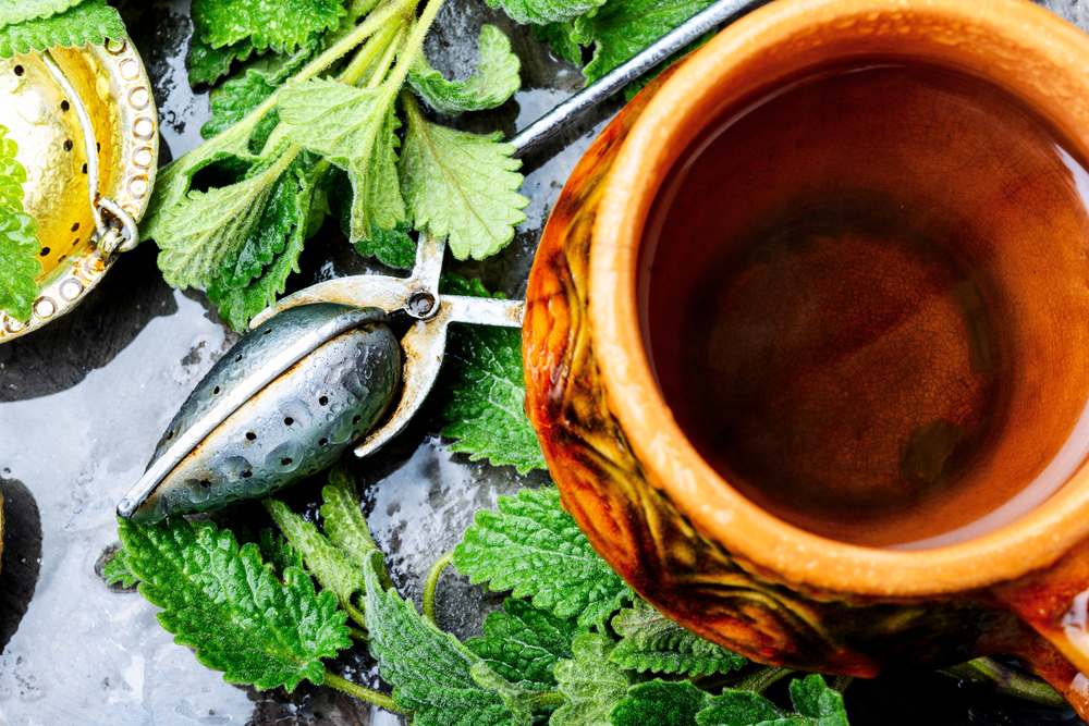Natural melissa herbal tea.Green melissa herbal tea in cup. Tea with green fresh melissa leaves
