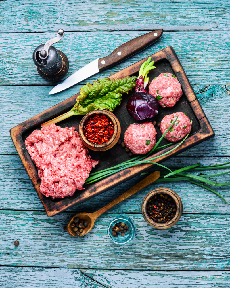 Fresh minced beef on cutting board and ingredients.Raw mixed minced meat meatballs. Raw ground beef