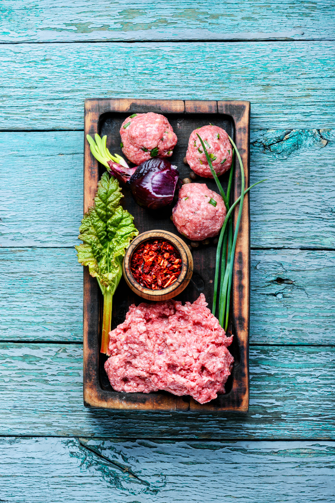 Fresh raw minced beef on cutting board and ingredients.Mince.. Raw minced meat