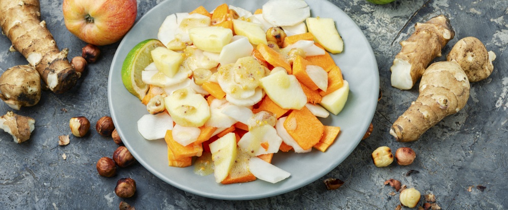 Natural salad with juicy apple,carrot and Jerusalem artichoke.Healthy food. Vitamin salad with vegetables and fruits