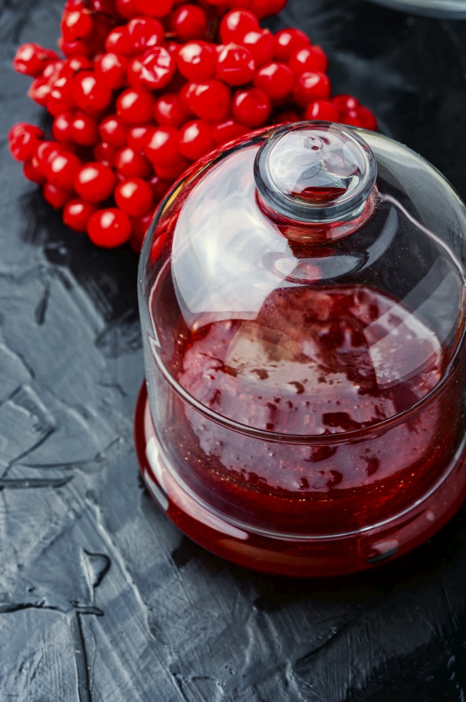 Glass jar with jam and fresh viburnum berries. Berries jam in glass jar