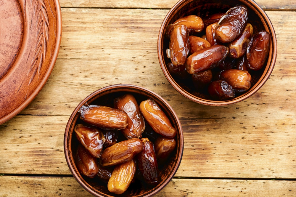 Dried date fruit in bowl.Traditional oriental sweets. Dried date on old rustic wooden table