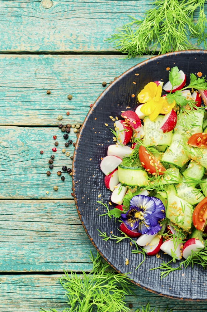 Spring salad with vegetables and edible flowers.Dieting concept. Healthy vegetables salad