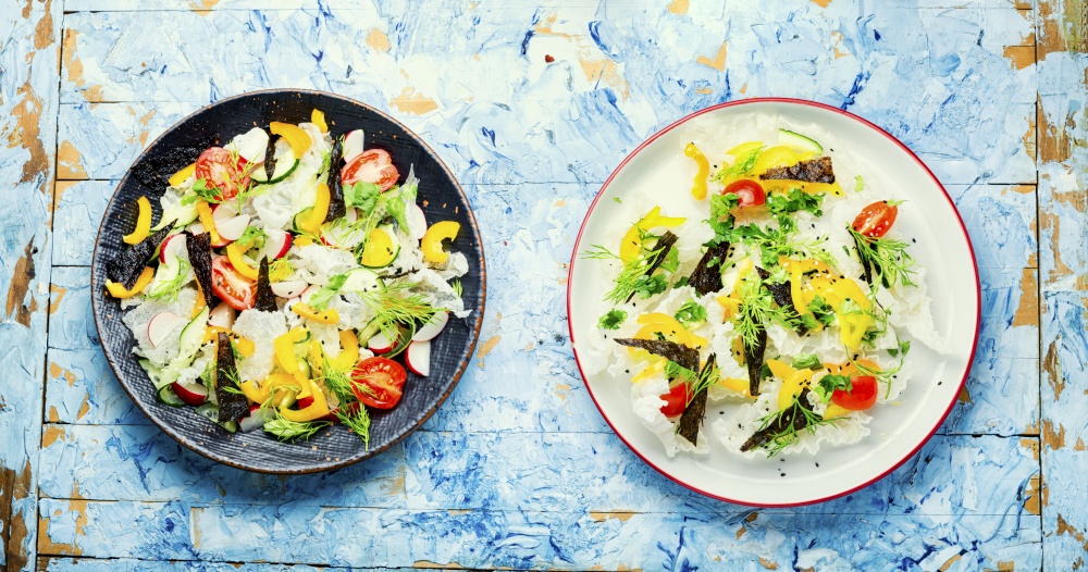 Spring fresh vegetable salad on rice paper.Vegetable oriental salad.. Vegetable salad decorated with rice paper,green salad