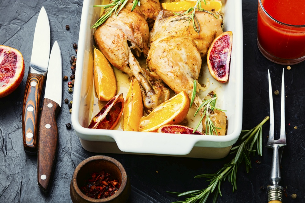 Grilled chicken meat with orange sauce and rosemary in a baking dish.Baked chicken drumstick. Roasted chicken with oranges